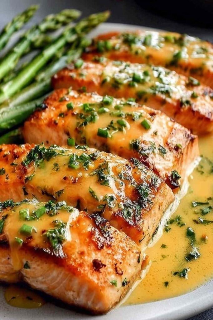 Bang Bang Salmon fillets drizzled with creamy sweet chili sauce and topped with green onions on a white plate