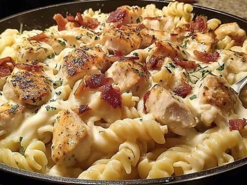 Chicken Bacon Ranch Pasta in a skillet with creamy sauce and bacon garnish