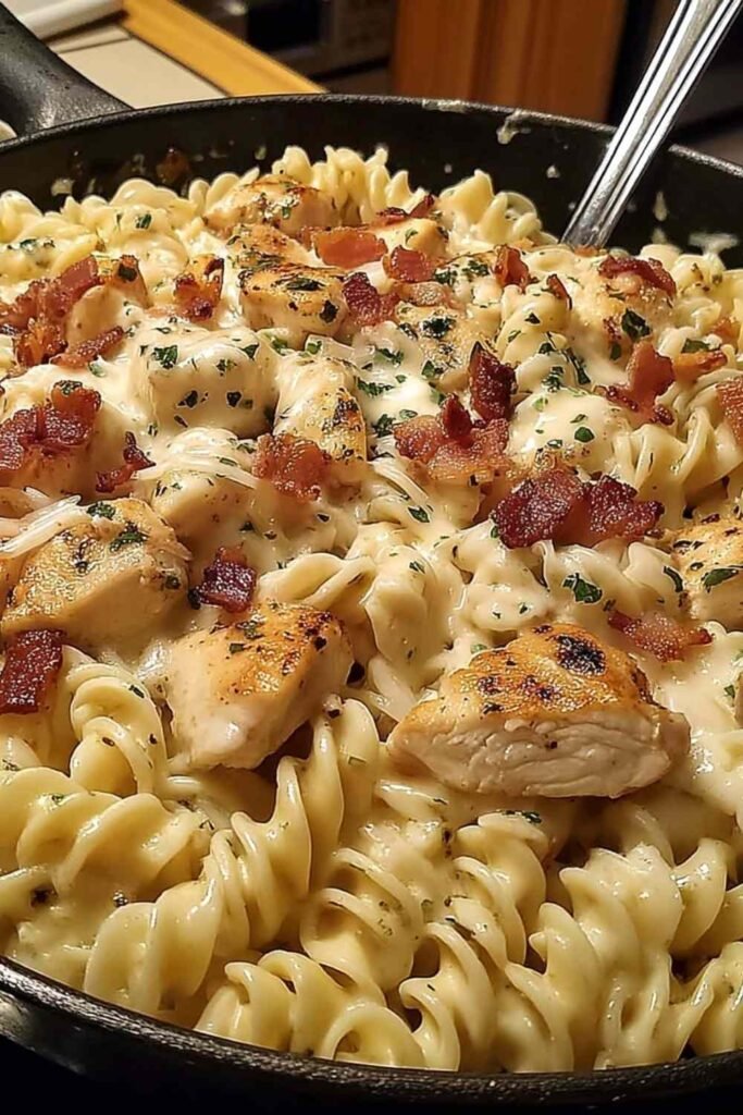 Chicken Bacon Ranch Pasta in a skillet with creamy sauce and bacon garnish