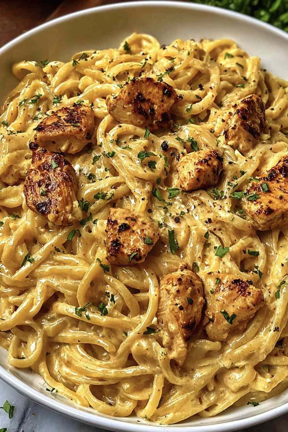 Creamy Cowboy Butter Chicken Pasta in a skillet with golden chicken slices and garlic butter cream sauce over fettuccine