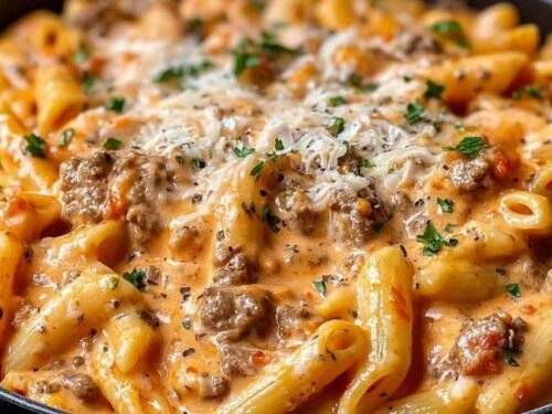 Creamy beef pasta in a white bowl garnished with parsley