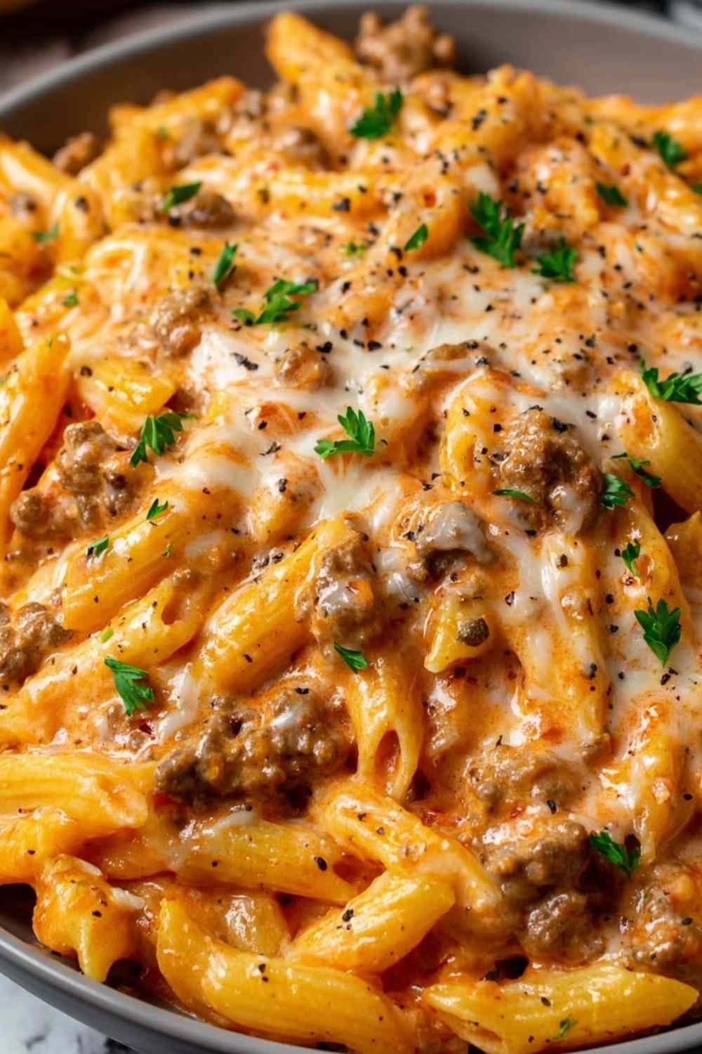 Creamy beef pasta in a white bowl garnished with parsley