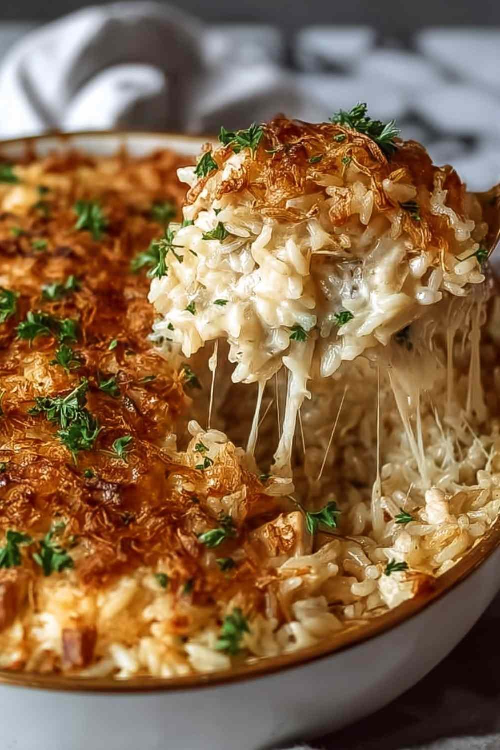 French Onion Chicken Rice Bake in a white baking dish with golden crispy onions and melted cheese on top