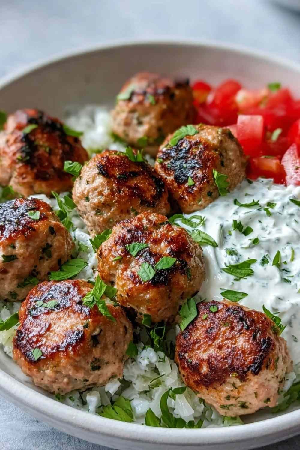 Greek Turkey Meatballs with Tzatziki ingredients mixed in a bowl
