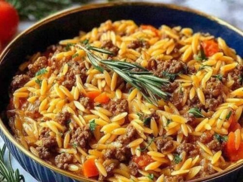 Creamy ground beef orzo recipe served in a large skillet topped with freshly grated Parmesan cheese