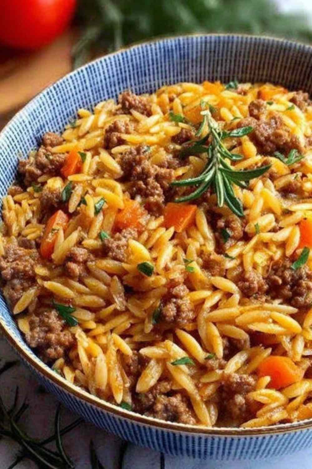 Creamy ground beef orzo recipe served in a large skillet topped with freshly grated Parmesan cheese