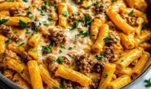 High protein creamy beef pasta served in a skillet with Parmesan and fresh parsley garnish
