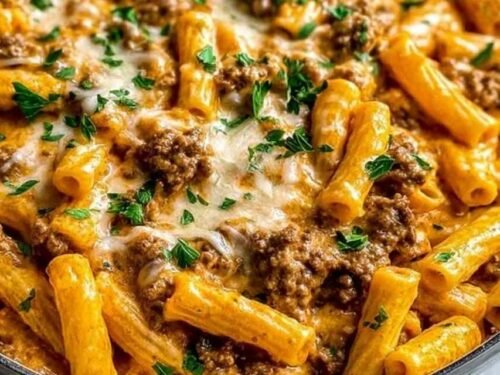 High protein creamy beef pasta served in a skillet with Parmesan and fresh parsley garnish