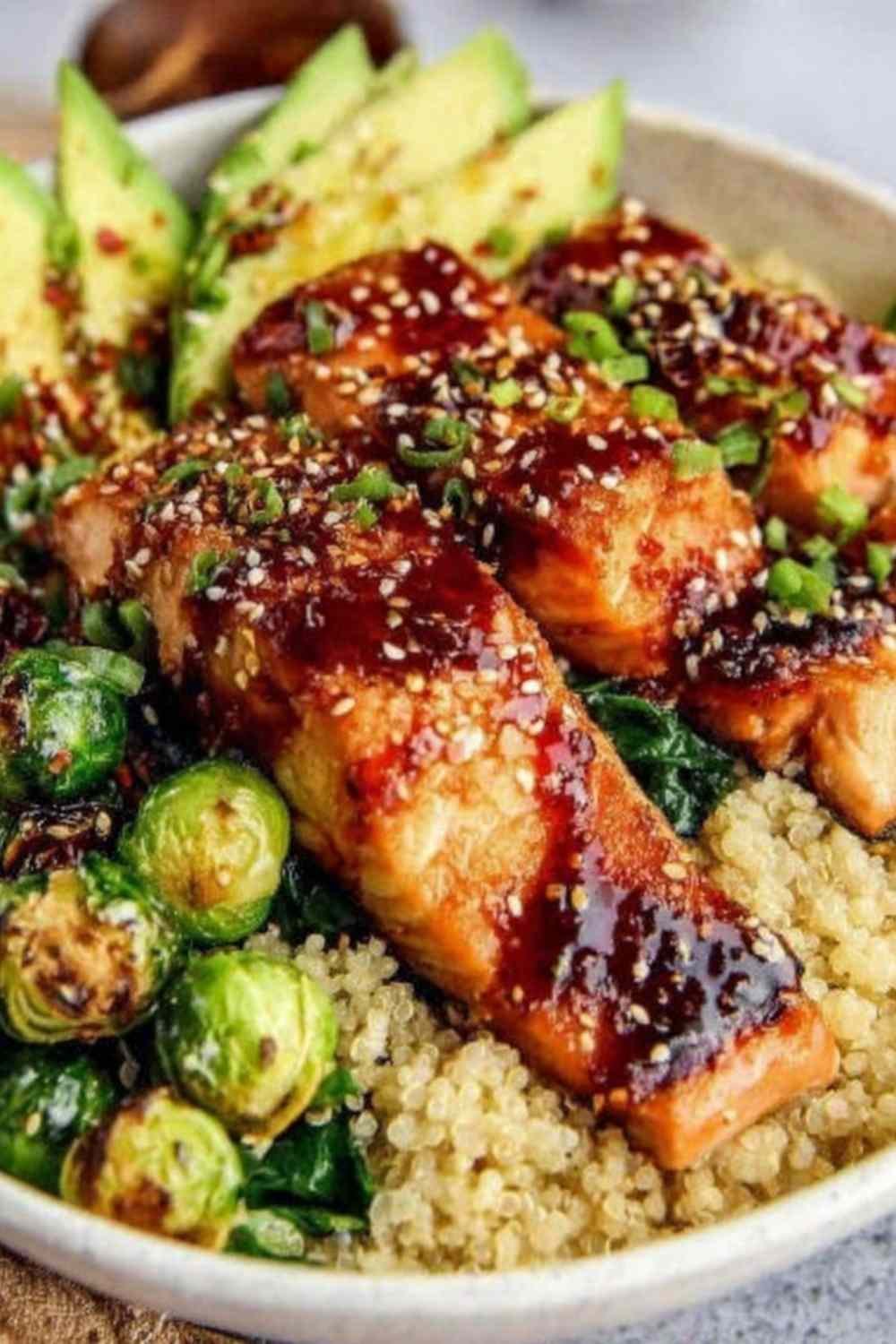 Brushing honey glaze onto salmon fillets in a skillet for Honey Glazed Salmon Bowl