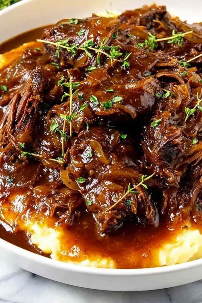 Juicy French Onion Pot Roast with caramelized onions and fresh herbs in a Dutch oven