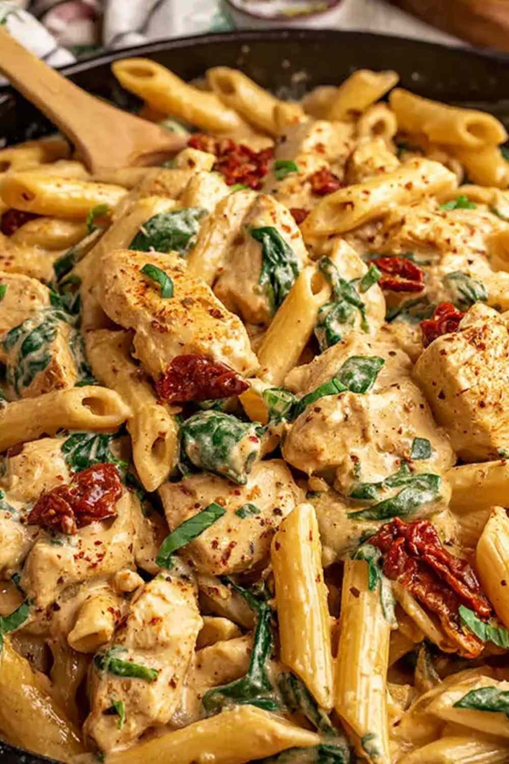Marry Me Chicken Pasta in a creamy sun-dried tomato sauce in a cast iron skillet