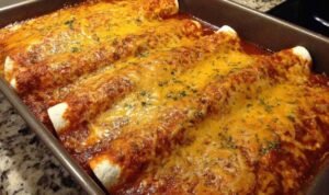 Queso Chicken Enchiladas Queso Chicken Enchiladas baking in a glass dish with melted cheese