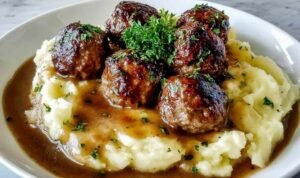 Salisbury Steak Meatballs Salisbury Steak Meatballs with gravy served over garlic mashed potatoes on a white plate