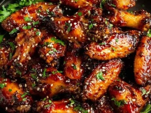 Sweet and Spicy Chicken Wings coated in sticky glaze on a white platter