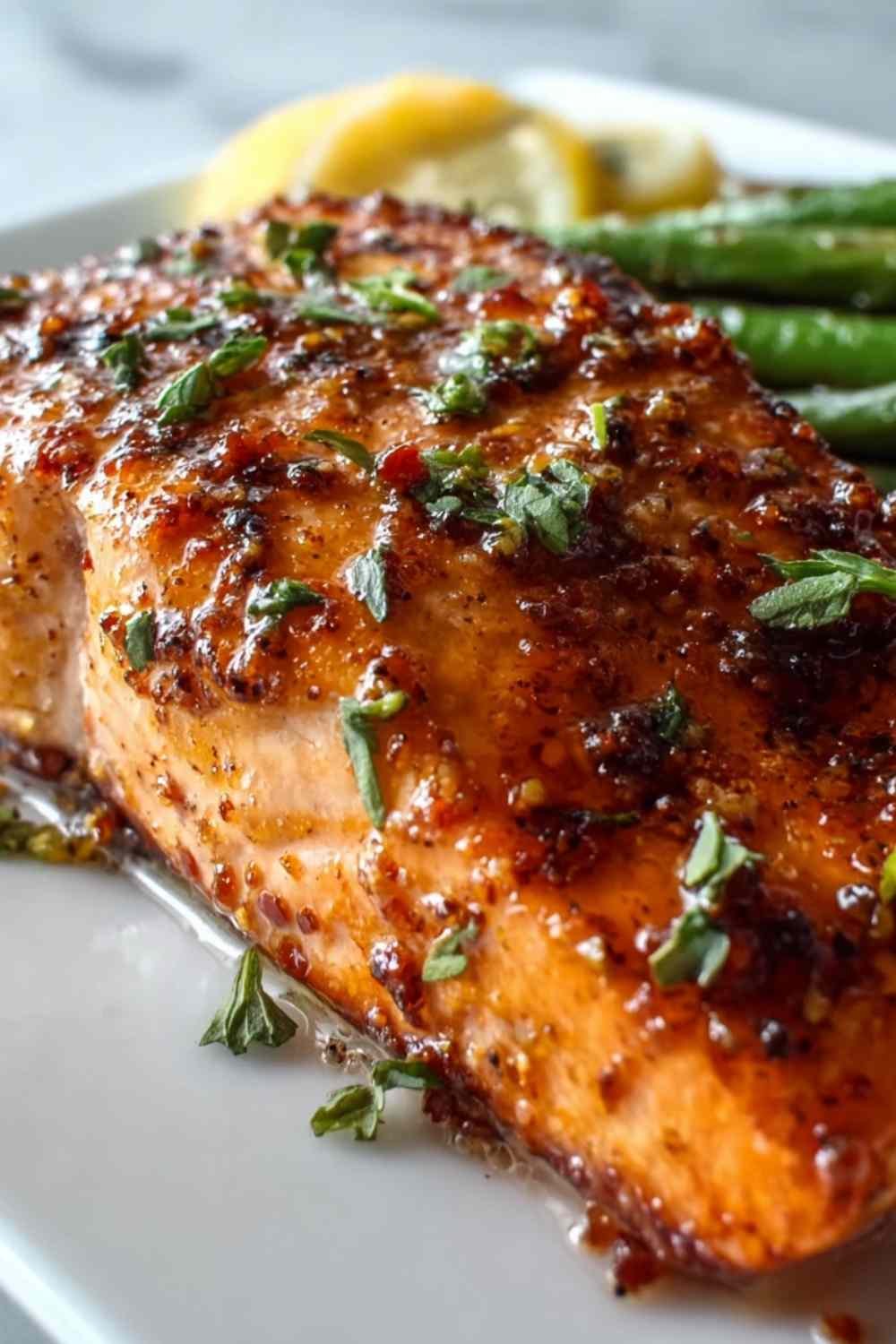 Texas Roadhouse Salmon on a white plate garnished with fresh parsley and lemon wedges