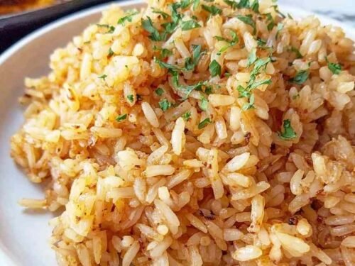 Texas Roadhouse Seasoned Rice cooking in a cast iron skillet