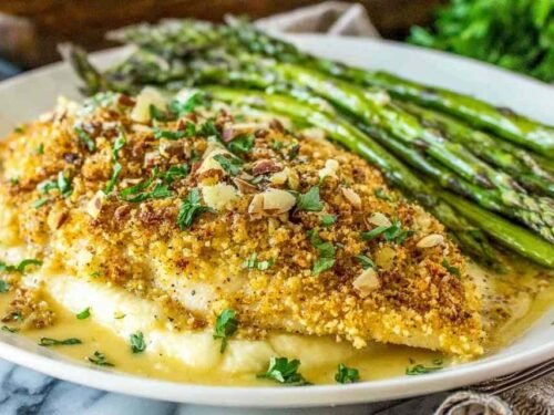 Almond-crusted honey dijon tilapia served over creamy parmesan polenta with honey mustard sauce drizzled on top