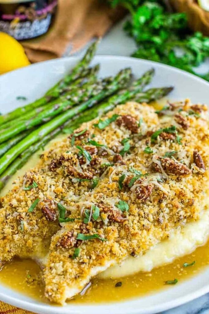 Almond-crusted honey dijon tilapia served over creamy parmesan polenta with honey mustard sauce drizzled on top