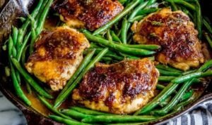 Asian Seared Chicken with Stir Fried Green Beans Asian seared chicken thighs with crispy golden skin cooking in a cast iron skillet for stir fried green beans recipe