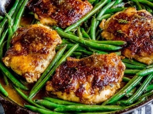 Asian seared chicken thighs with crispy golden skin cooking in a cast iron skillet for stir fried green beans recipe