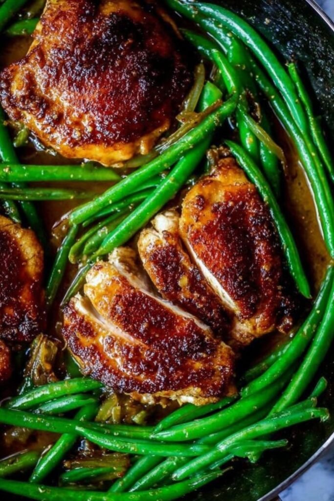 Asian seared chicken thighs with crispy golden skin cooking in a cast iron skillet for stir fried green beans recipe
