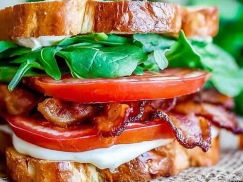 Classic BLT sandwich recipe sliced in half showing layers of crispy bacon, fresh tomato, lettuce, and avocado on toasted white bread