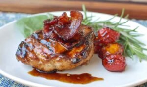 Juicy grilled chicken spicy honey bacon glaze served on a white plate with grilled vegetables