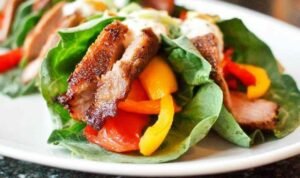 Sliced barbeque pork tenderloin on a white plate seasoned with a smoky homemade dry rub