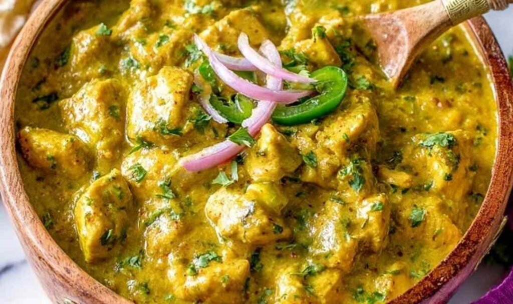 Chicken curry simmering in a skillet with fresh cilantro