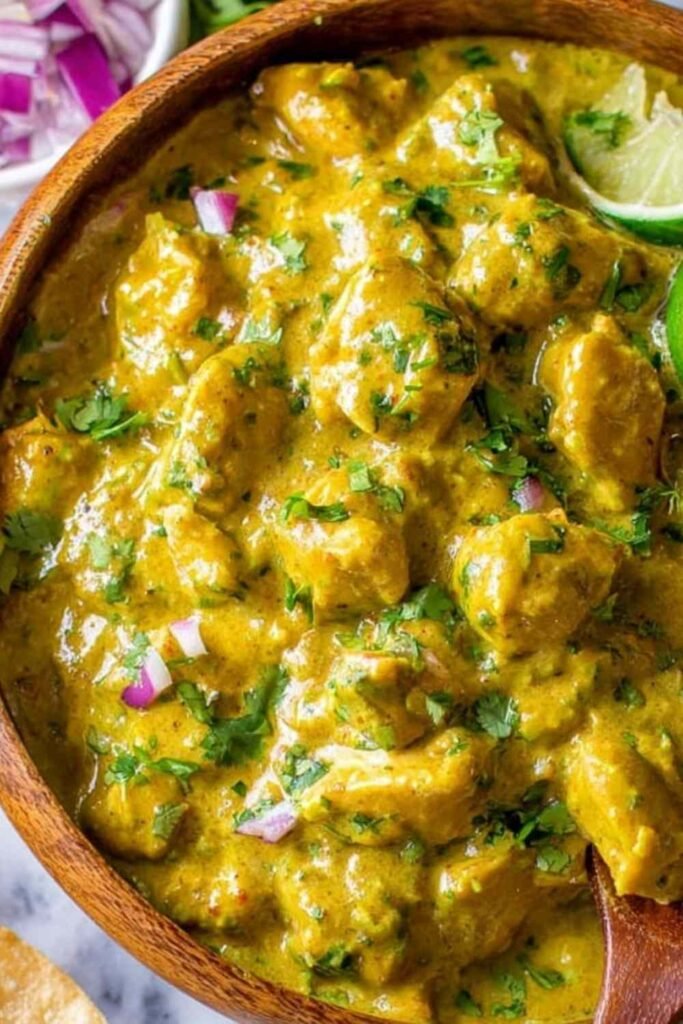 Chicken curry simmering in a skillet with fresh cilantro