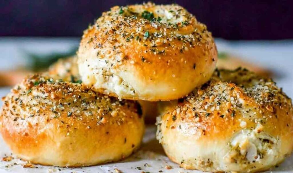 Golden chicken mushroom cream cheese stuffed rolls on a parchment-lined baking sheet fresh from the oven