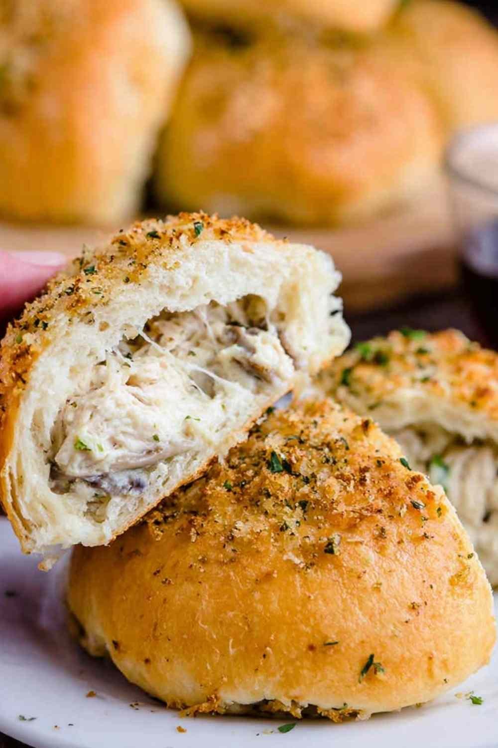 Golden chicken mushroom cream cheese stuffed rolls on a parchment-lined baking sheet fresh from the oven