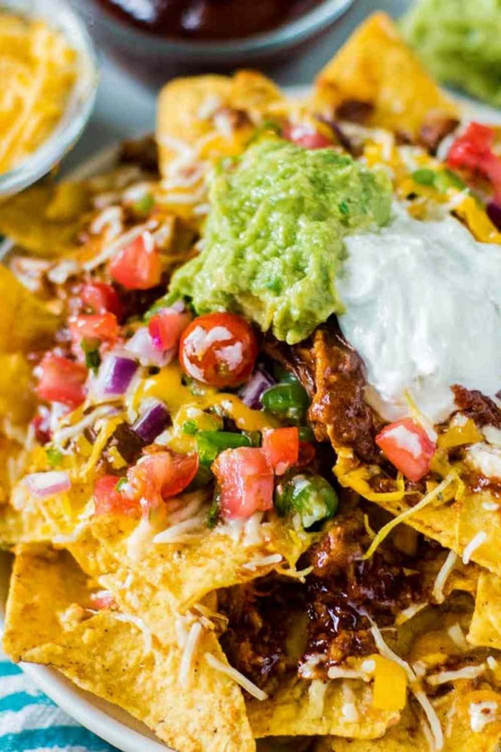 Easy rotisserie chicken nachos loaded with melted cheese and black beans fresh from the oven on a sheet pan