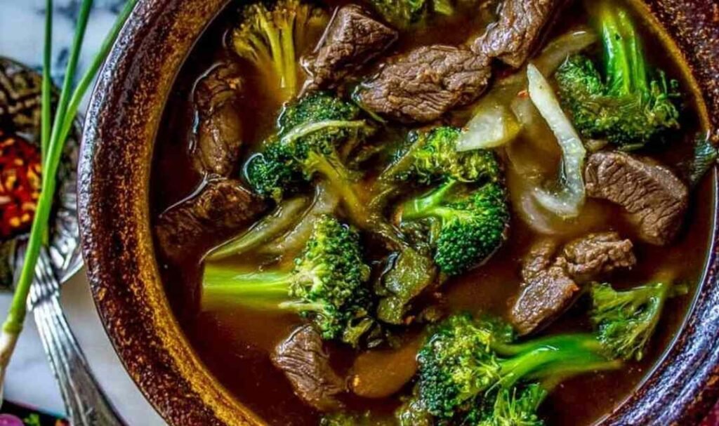 Bowl of Chinese beef and broccoli soup with tender flank steak slices and crisp broccoli florets in a dark savory broth