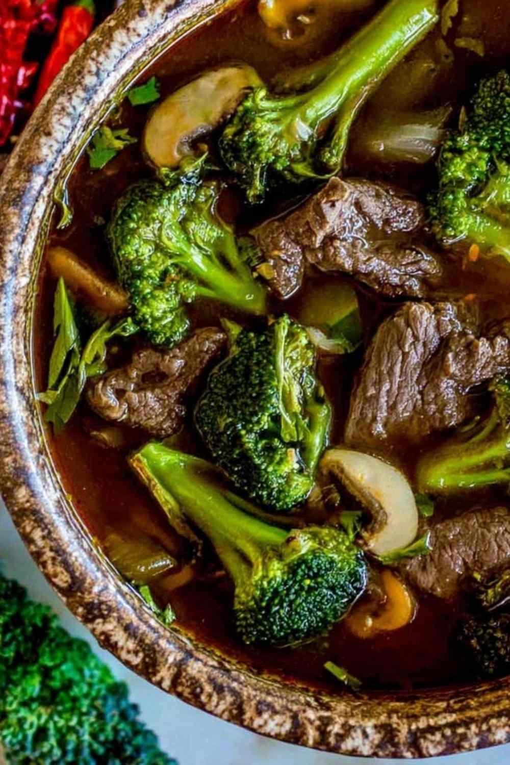 Bowl of Chinese beef and broccoli soup with tender flank steak slices and crisp broccoli florets in a dark savory broth