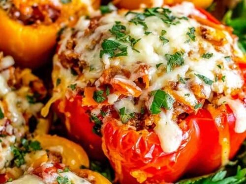Classic stuffed bell peppers topped with golden melted mozzarella cheese in a white baking dish fresh from the oven