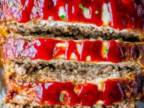 Sliced cream cheese stuffed meatloaf showing a creamy filling on a white serving plate