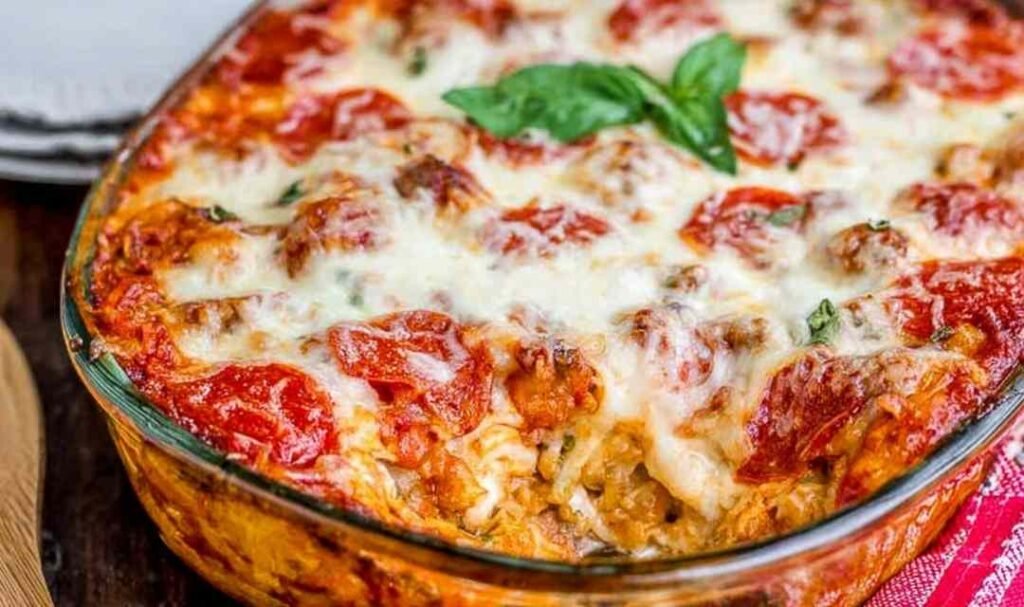 Easy pizza casserole with golden biscuits, melted mozzarella, and pepperoni fresh out of the oven in a 9x13 casserole dish