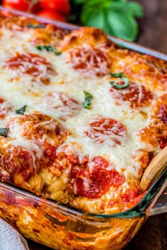 Easy pizza casserole with golden biscuits, melted mozzarella, and pepperoni fresh out of the oven in a 9x13 casserole dish