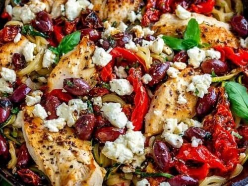 Greek pasta with chicken strips, kalamata olives, artichoke hearts, and crumbled feta cheese in a large skillet