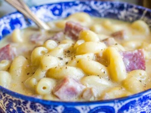 Creamy ham mac and cheese soup in a white bowl with chunks of diced ham and tender macaroni noodles