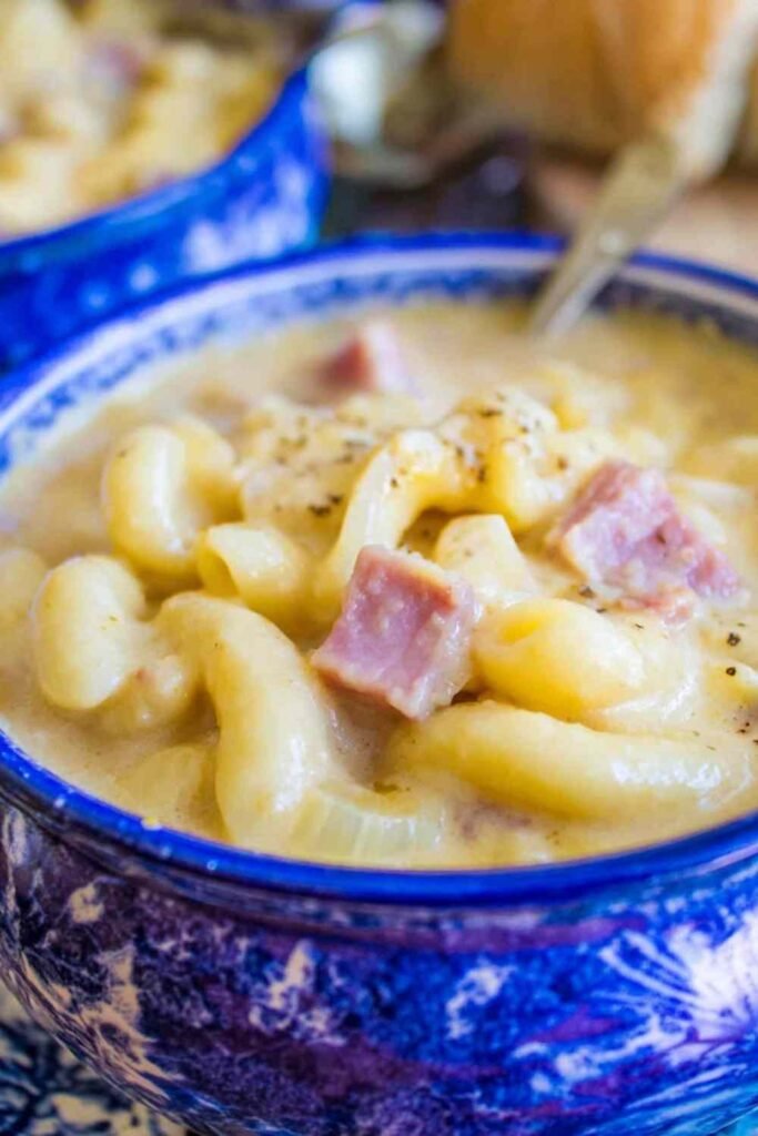 Creamy ham mac and cheese soup in a white bowl with chunks of diced ham and tender macaroni noodles