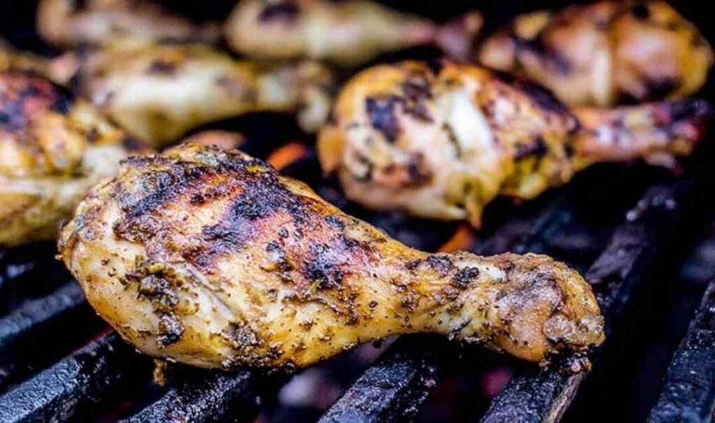 Seasoned chicken drumsticks and bone-in thighs on a plate ready to make lemon tarragon grilled chicken
