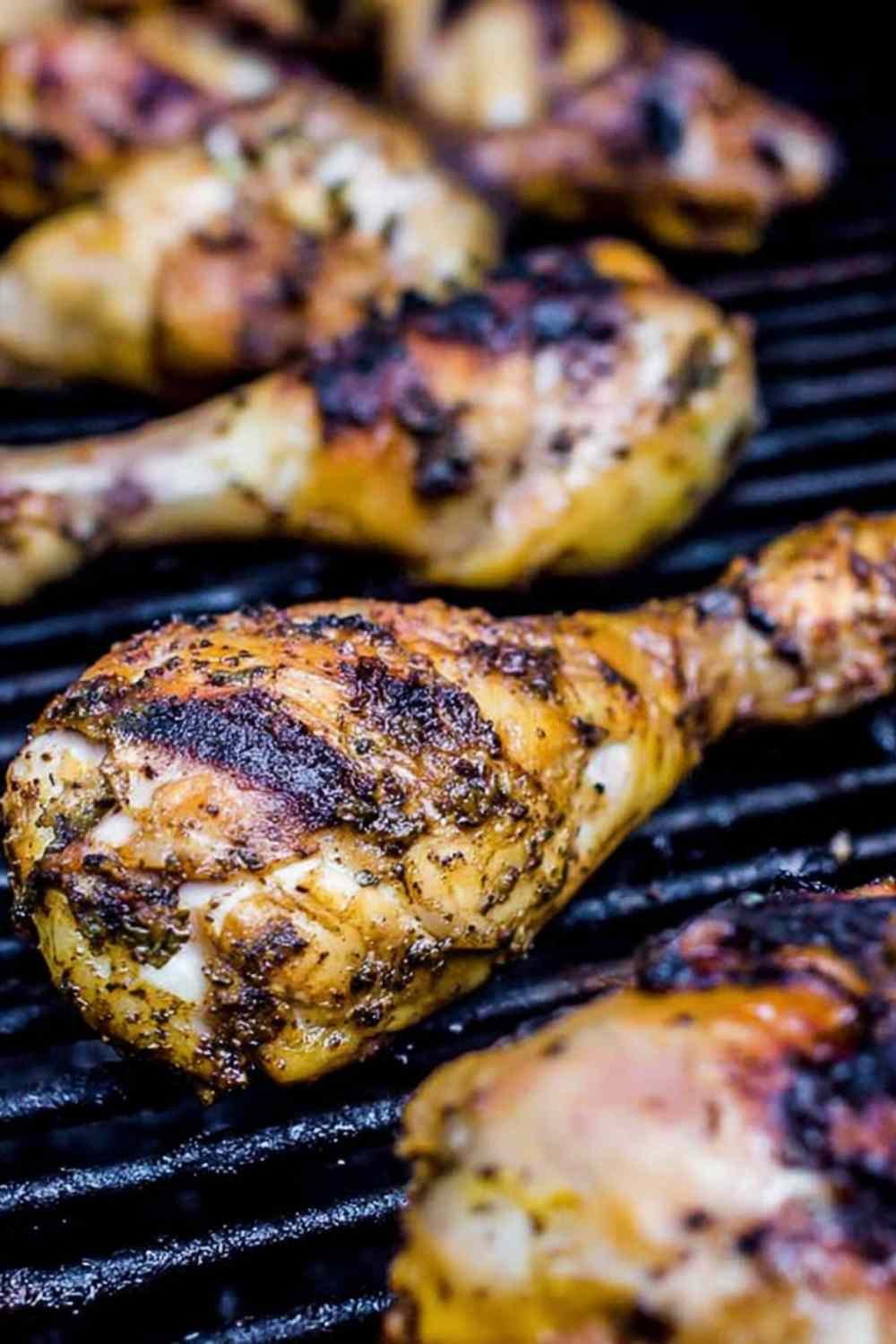Seasoned chicken drumsticks and bone-in thighs on a plate ready to make lemon tarragon grilled chicken