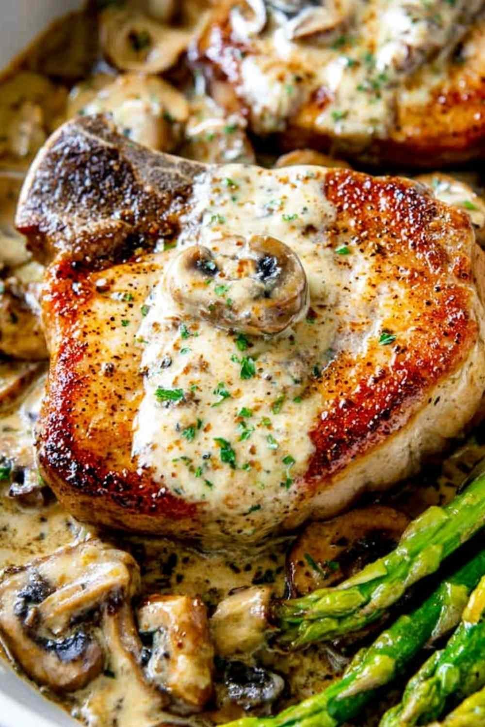 Pan seared pork chops with creamy mushroom sauce, asparagus, and fresh thyme in a cast iron skillet