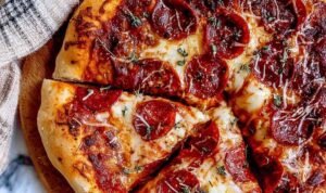 Pizza Dough Hands kneading a smooth pizza dough recipe in a bowl.
