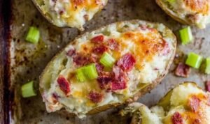 Reuben stuffed twice baked potatoes Reuben stuffed twice baked potatoes topped with melted Swiss cheese and garnished with chopped dill pickles on a greased sheet pan