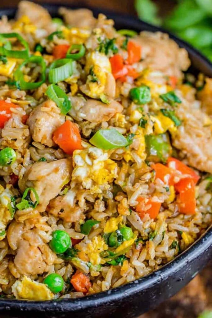 Sheet pan chicken fried rice with peas, carrots, red bell pepper, and green onions fresh out of the oven