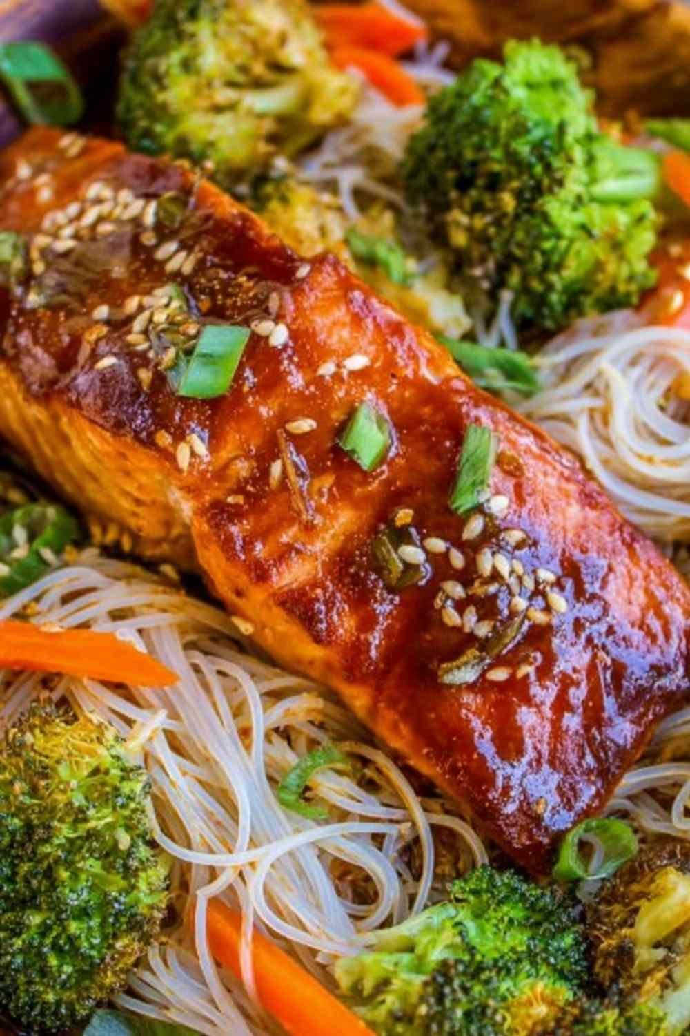 Sheet pan Asian salmon with broccoli and carrots roasted in soy ginger sauce on a rimmed sheet pan