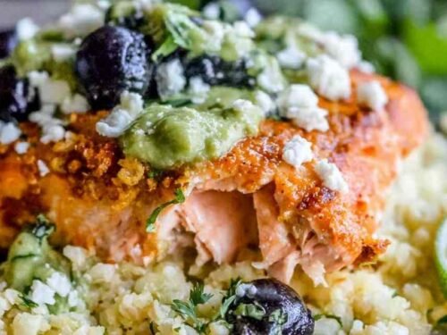 Sheet pan honey chipotle salmon with cauliflower rice, black beans, and avocado coconut cream on a baking sheet